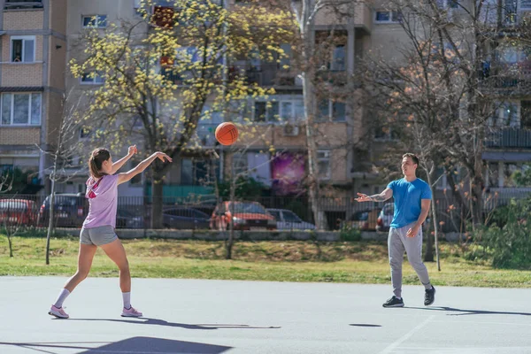 体育女孩把篮球传给了她的男朋友 — 图库照片
