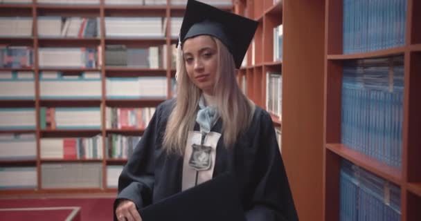 Examen Kvinnlig Student Höjer Stolt Sitt Diplom Universitetsbibliotekets Rum Universitetsutbildningskoncept — Stockvideo