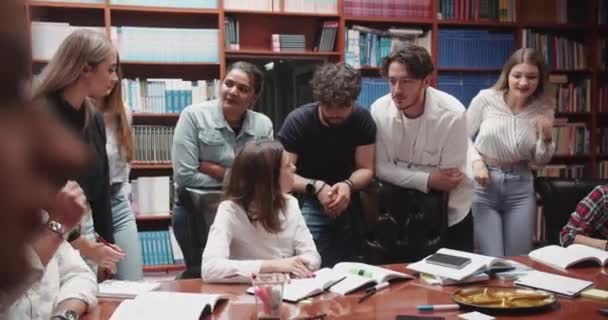 Kalabalık Bir Üniversite Kütüphanesinde Çeşitli Üniversite Öğrencileri Bir Masanın Etrafında — Stok video