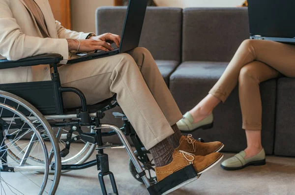 Hombre Discapacitado Silla Ruedas Trabajando Lap Top Mujer Sentada Sofá —  Fotos de Stock