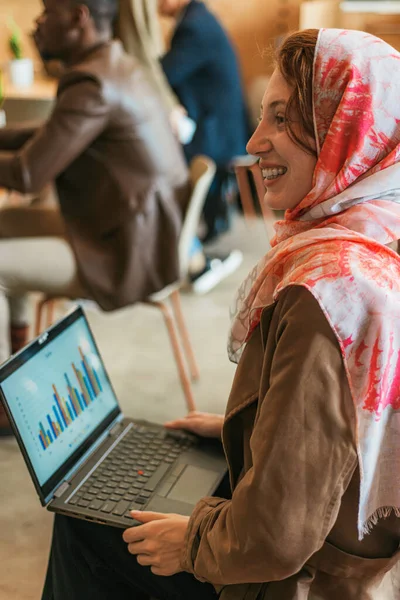负责销售报告的穆斯林女性员工 她正在和同事交谈 面带微笑 — 图库照片