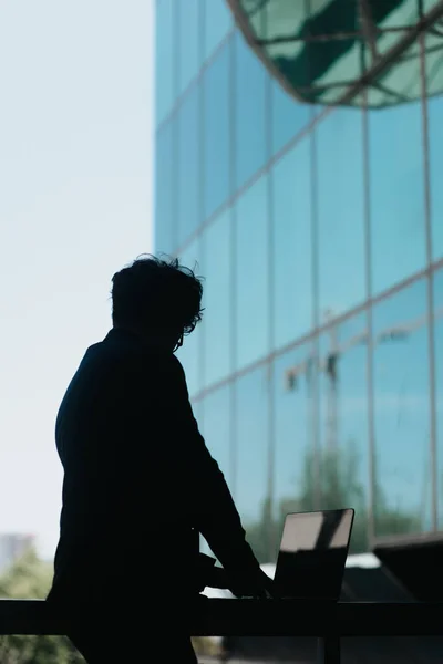 Man Med Vågigt Hår Arbetar Laptop Placeras Ett Metallstaket Framför — Stockfoto