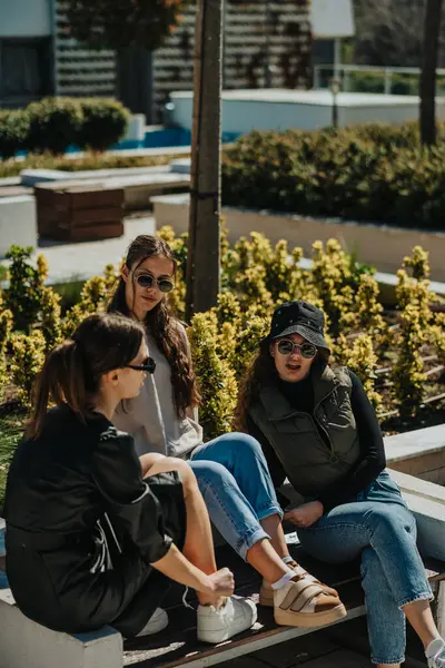 Three Girls Enjoying Sun Outdoors Sitting Bench Having Conversation — Stock Photo, Image