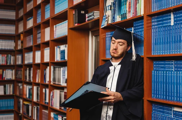 Üniversite Diplomasına Kütüphanede Bakan Genç Üzgün Bir Mezun — Stok fotoğraf