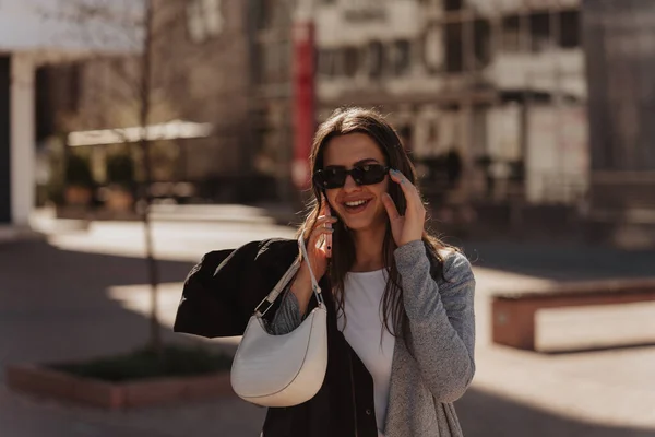 Όμορφη Μελαχρινή Κοπέλα Μιλάει Στο Τηλέφωνό Της Ενώ Χαμογελά Και — Φωτογραφία Αρχείου