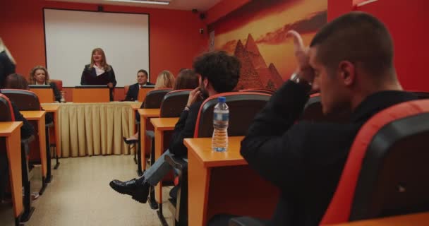 학생이 그녀의 졸업장을 방어하는 교수진에서 시험에 참석하는 학생과 교수의 — 비디오