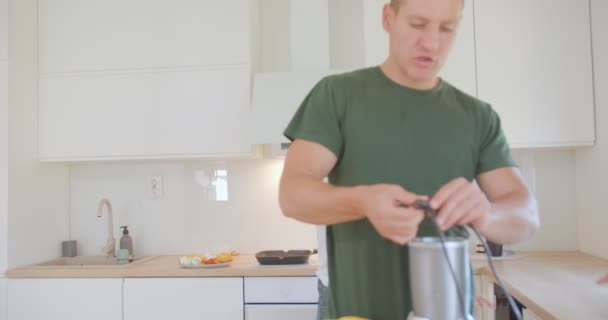 Oğlu Mutfak Tezgahındayken Meyve Sıkacağının Kablolarını Çözmeye Çalışıyor — Stok video