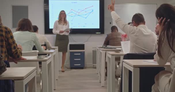 老年人举手向老师 在办公室教室里参加研讨会的各色人等致意 — 图库视频影像