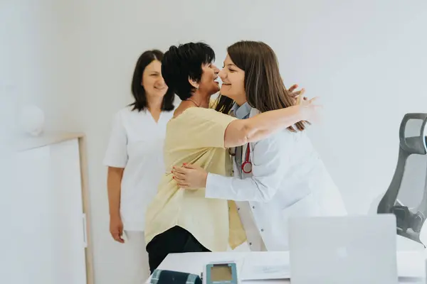 Experienced Doctor Sharing Positive News with Overjoyed Elderly Patient. Overjoyed, Satisfied, Elderly Woman Hugging her Doctor After She Shared Positive Results With Her.