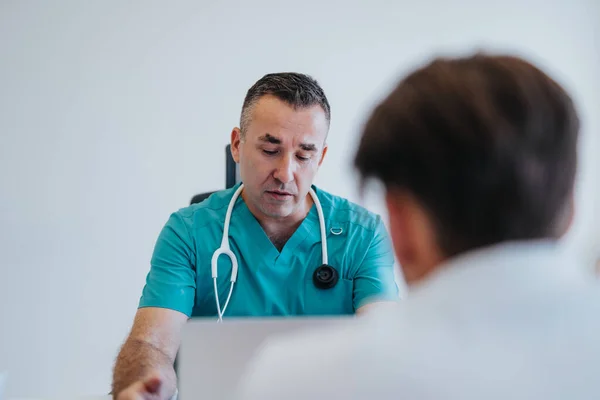 臨床訪問中に患者との診断を議論する経験豊富な医師 — ストック写真