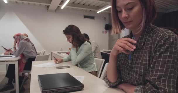 Sınıftaki Diğer Öğrencilerle Çevrili Güzel Bir Genç Kadın Sınava Giriyor — Stok video