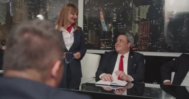 会議室で会議室でビジネス問題を議論するシニアマネージャーは 赤いネクタイで均一な衣装を着て 女性が立って話す — ストック動画