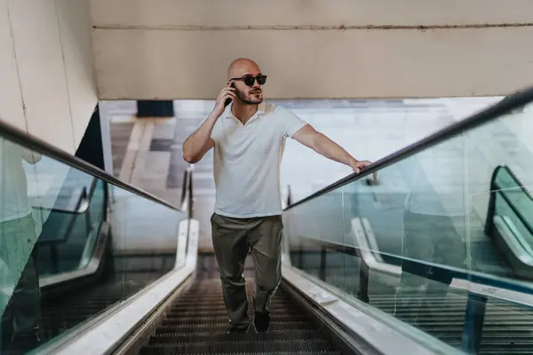Front view photo of businessman walking on escalator.