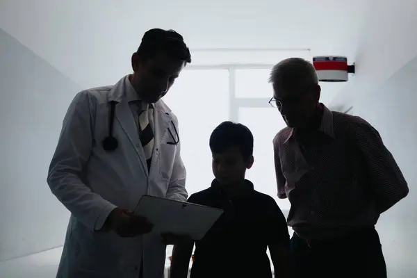 Experienced General Physician Discussing Diagnosis and Treatment Options for a Young Patient in a Clinic