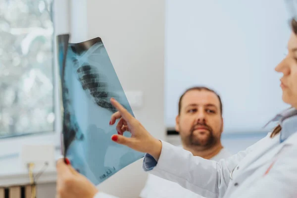 Médicos Con Experiencia Revisando Los Resultados Radiografía Con Paciente —  Fotos de Stock