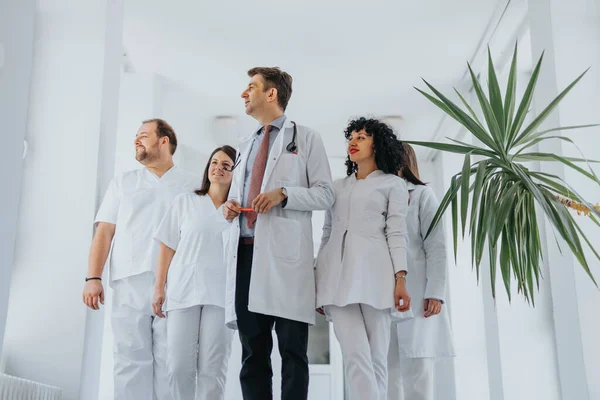 Grupo Médicos Confiados Uniformes Médicos Caminando Por Sala Hospital Mirando —  Fotos de Stock