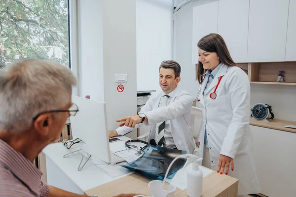 Médicos Discutiendo Resultados Rayos Con Pacientes Ancianos Clínica Ofreciendo Soluciones —  Fotos de Stock