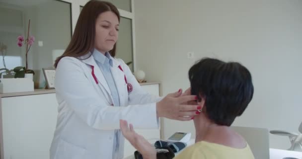 一位老年女病人正在和她的专科医生谈论她的健康问题 一位经验丰富的女专家正在准备检查她的病人 她拿了个电视喉镜 — 图库视频影像