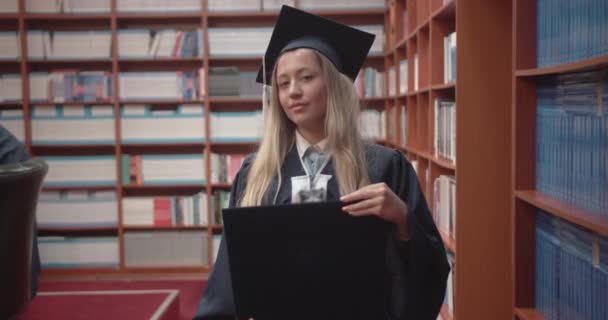 Absolwentka Studentka Dumą Trzymająca Dyplom Bibliotece Uniwersyteckiej Koncepcja Edukacji Uniwersyteckiej — Wideo stockowe