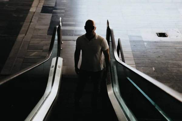 Front view photo of businessman walking on escalator. Silhouette photo.
