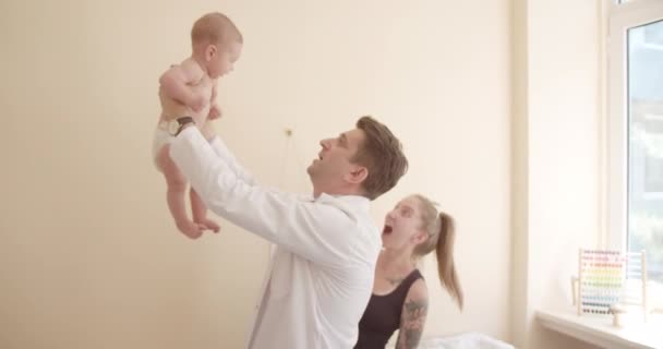 Homem Feliz Médico Pediatra Levantar Bebés Clínica Estão Sorrir Médico — Vídeo de Stock