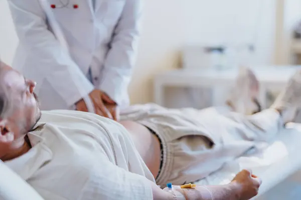 Einem Krankenhauszimmer Versorgt Ein Arzt Einen Patienten Professionell Überprüft Berichte — Stockfoto