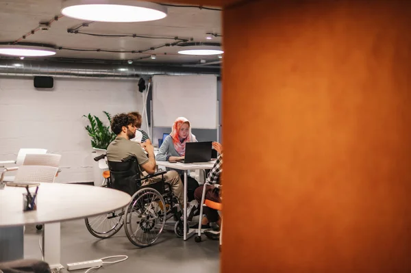オフィスで障害者同僚とのブレインストームセッションを持つインクルーシブ労働者のチーム — ストック写真