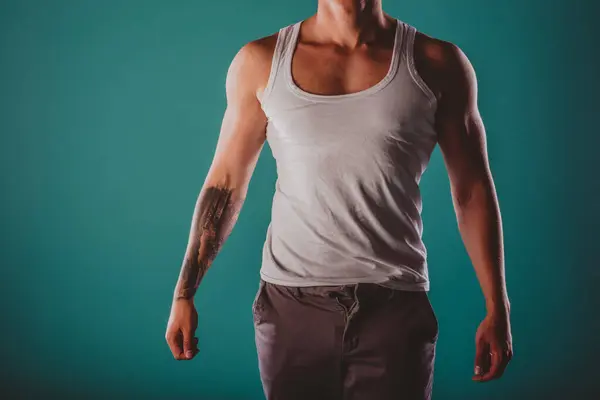 Ein Selbstbewusster Fitter Mann Posiert Mit Muskulösem Körperbau Auf Türkisfarbenem — Stockfoto