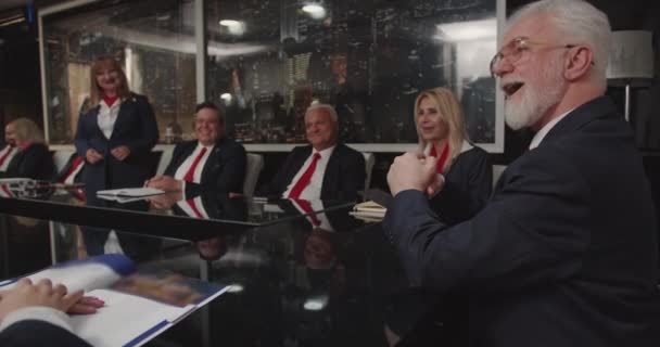 在董事会中 高级经理们全神贯注地讨论业务问题 他们都穿着红色领带装饰的配套制服 一个女人站在那里 负责谈话 — 图库视频影像