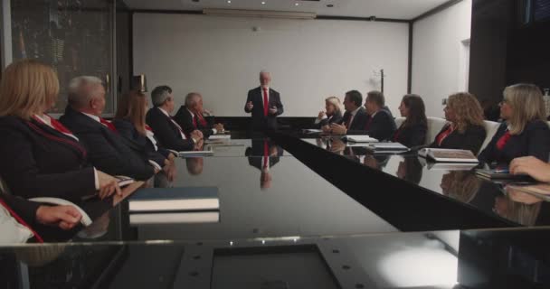 在一个公司董事会中 高级管理人员聚在一起讨论重要的业务问题 他们穿着红色领带的制服装束 呈统一战线 — 图库视频影像