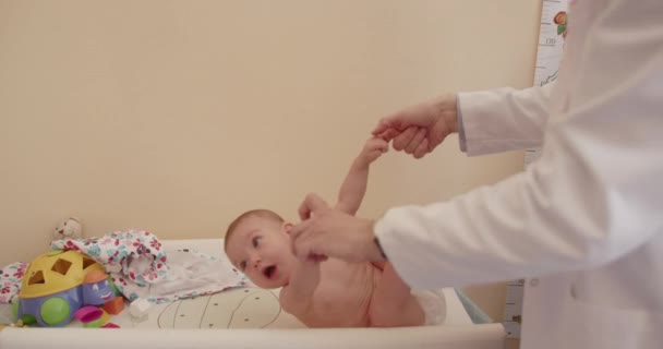 Мужчина Старший Врач Осматривает Новорожденного Ребенка Больнице Держит Свои Пальцы — стоковое видео
