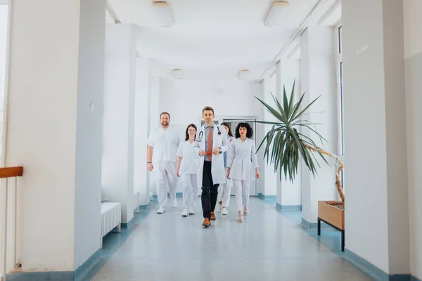 Grupa Zaufanych Lekarzy Spacerujących Korytarzem Szpitalnym Pokazując Swój Profesjonalizm Oddanie — Zdjęcie stockowe