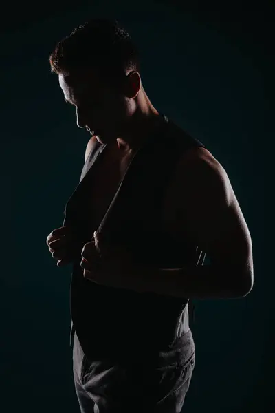 黒い背景にシルエットで筋肉を表示する強力な男性アスリート — ストック写真