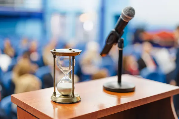 Zbliżenie Zegara Piaskiem Obok Mikrofonu Sali Konferencyjnej Pełnej Ludzi — Zdjęcie stockowe