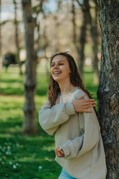 Papatya Çayı Tutan Parkta Ağaca Yaslanan Güzel Bir Kız Gülümsüyor — Stok fotoğraf