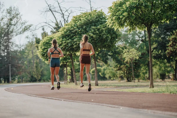 緑の屋外環境でジョギングするフィット女性 ワークアウトのモチベーションを刺激する — ストック写真