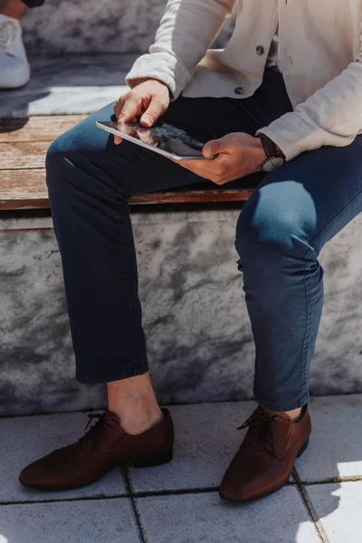 タブレットを保持する屋外のベンチに座っているスタイリッシュなビジネスマン クロップされた写真 — ストック写真