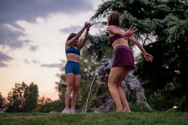 Подтянутые Девушки Весело Плещущие Играющие Водой Парке Теряются После Тренировок — стоковое фото