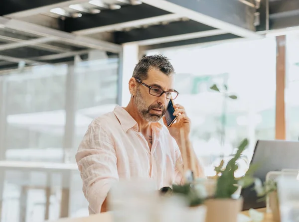 Ofiste Dizüstü Bilgisayarla Çalışırken Telefonla Konuşan Yakışıklı Bir Adamı Erkek — Stok fotoğraf