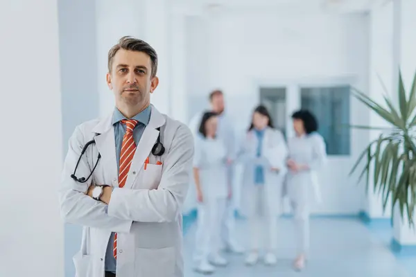 A portrait of successful and confident medical person posing with a group of doctors in the back.