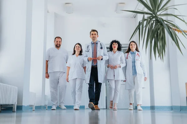 Grupo Doctores Experimentados Confiados Batas Laboratorio Caminan Pasillo Hospital Sonríen —  Fotos de Stock
