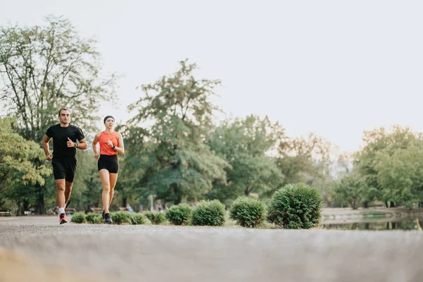 下午锻炼时一对健康的夫妇在公园里慢跑 — 图库照片