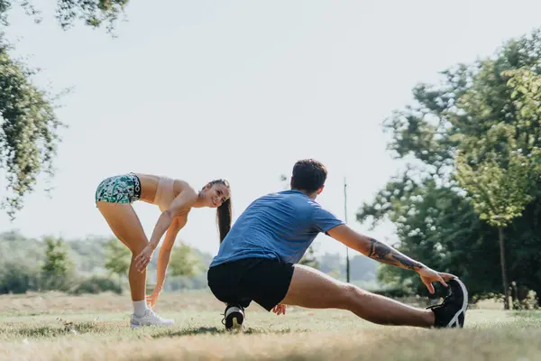 一对相貌匀称的白人夫妇在室外锻炼 在阳光充足的公园里伸展身体 有动力的职业运动员拥抱健康的生活方式和积极的结果心态 — 图库照片