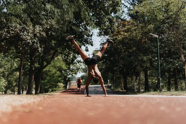身强力壮的运动员在阳光充足的公园里练习手推车 激发了运动的动力 展示了体育活动的成果 — 图库照片