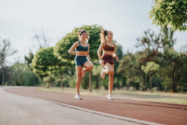 自然の中でジョギングするフィット感のある女性のグループは 運動と健康的なライフスタイルで他の人に刺激を与えます — ストック写真