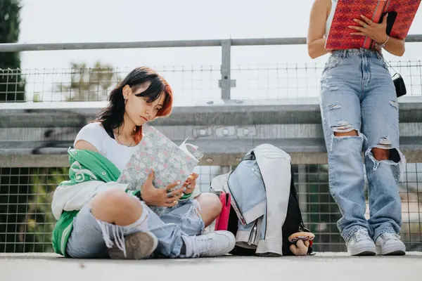 都市部の2人の高校生が屋外に座り 試験のために一緒に勉強しています 彼らのコラボレーションと友情は より良い成績と学習レッスンに貢献しています — ストック写真