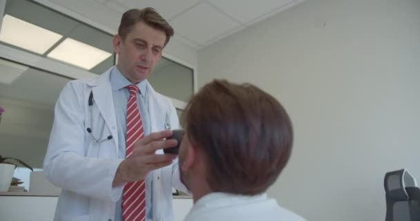 Tapasztalt Orvos Aki Alapos Egészségügyi Vizsgálatokat Végez Egy Klinikán Ellenőrzi — Stock videók