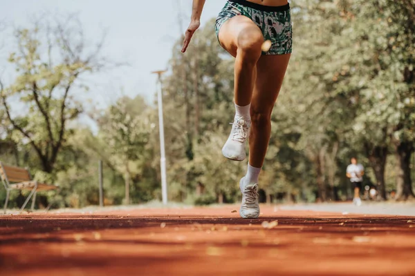 stock image Caucasian female runner sprinting, training outdoors in the park, improving fitness levels for a race.