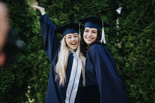 Friends Celebrating Academic Success Park University Graduates Gowns Caps Hugging — Stock Photo, Image