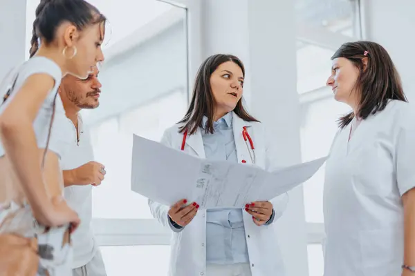 Erfahrene Gesundheitshelfer Diskutieren Mit Patienten Einem Belebten Kliniksaal Über Diagnostische — Stockfoto